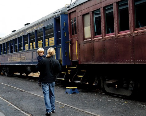 A young boy and his father get ready to board the Autumn Breeze train car. 