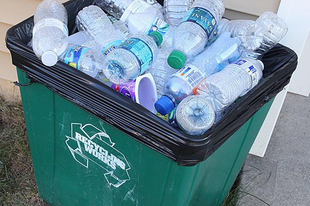 Students recycle plastic outside of their town house. 