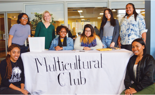 Left to right: Multicultural Club members Gardyney Deshommes, Noni Silas, Kierra Kimble, Habrienne Louchie, Chabely Espinal, Gabrielle Padilla, Tayler Fleming, and Creily Torres pose by their clubs sign-up and information table.