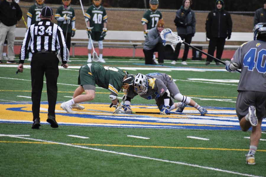 Garrett Heidecker, sophomore midfielder and faceoff, fights for possession during the
face off.