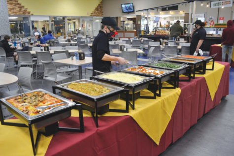A Metz worker checks over the thanksgiving dinner which consists of (from left to right) Wild Mushroom and Spinach Ravioli with a Roasted Tomato blush sauce, Vegetable and Herb stuffing, creamy mashed potatoes, Candied sweet potatoes, Green beans, Cheesy corn casserole and brown sugar carrots.