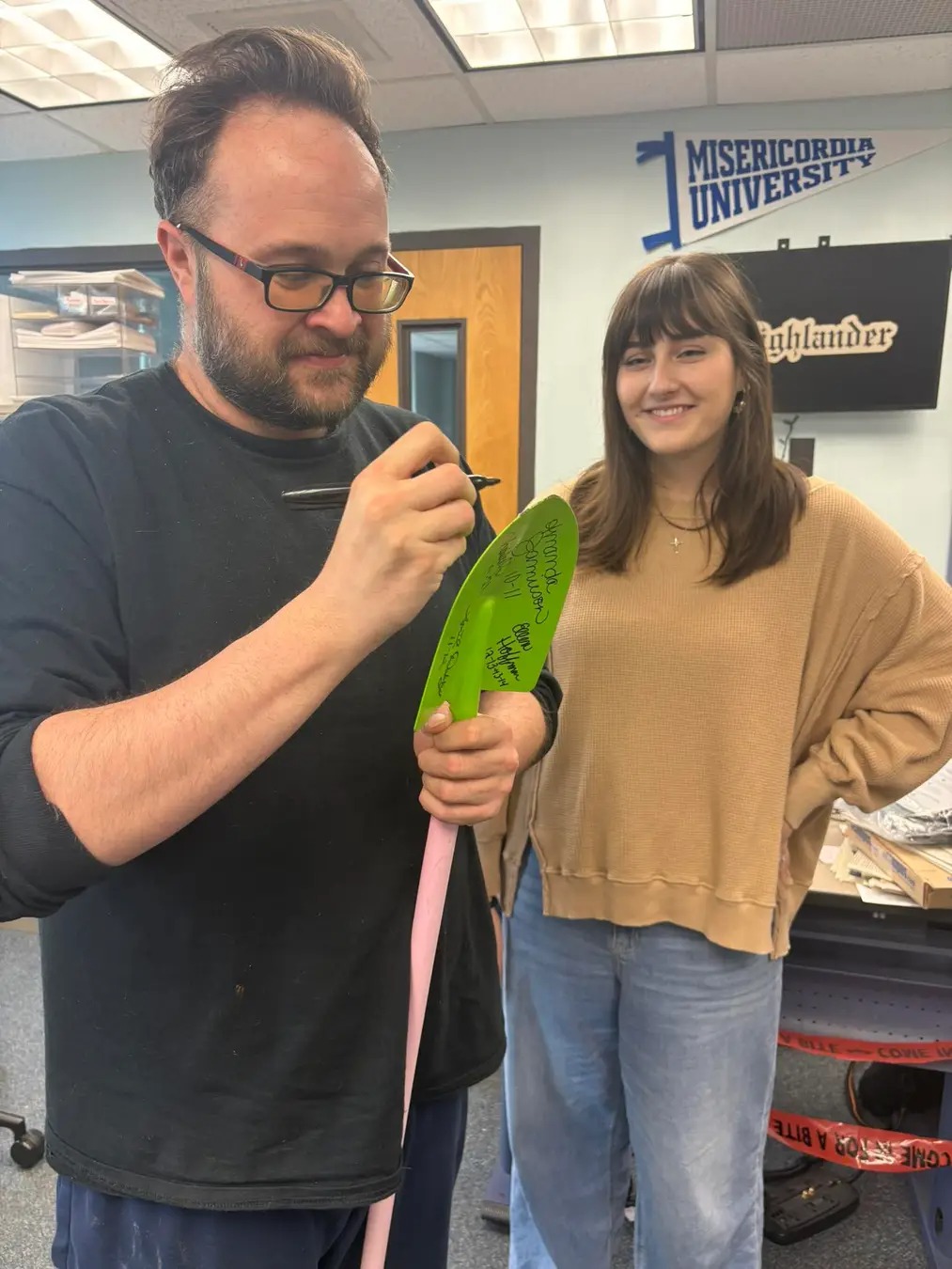 Former Editor-In-Chief Matt Warren welcomes new EIC Allyson Stroup, continuing the tradition of signing the shovel as a a symbol of the transfer of power. 
